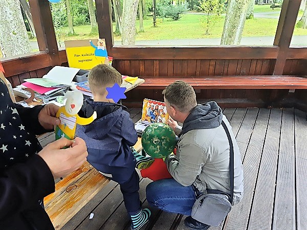 Mężczyzna i dziecko oglądają książkę.