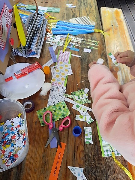 Dłonie dzieci, które wykonują kolorowe zakładki do książek. Materiały plastyczne.