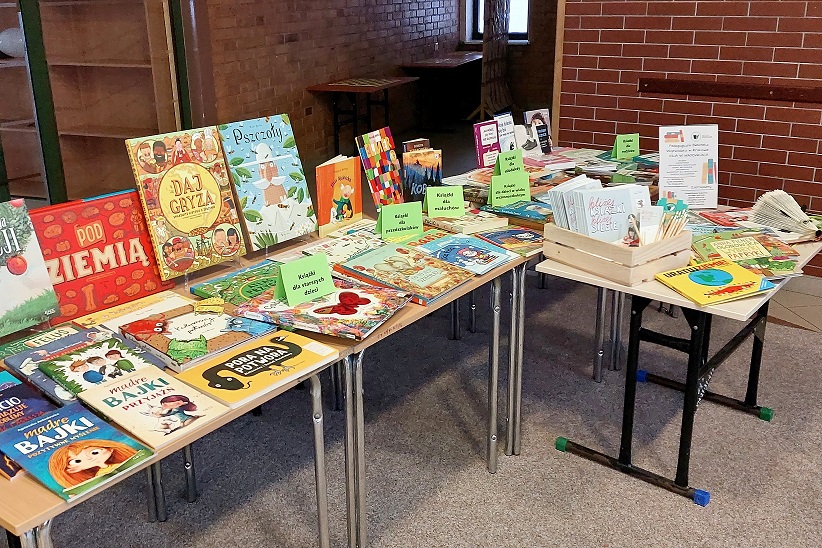 Książki dla dzieci i rodziców ułożone na stolikach.