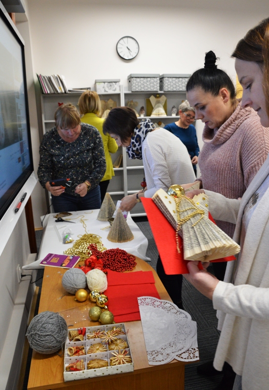 Uczestniczki ozdabiają swoje prace przygotowanymi materiałami świątecznymi